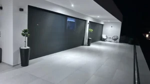 Pokrita panoramska okna in drsna vrata na balkonu z nočno osvetlitvijo